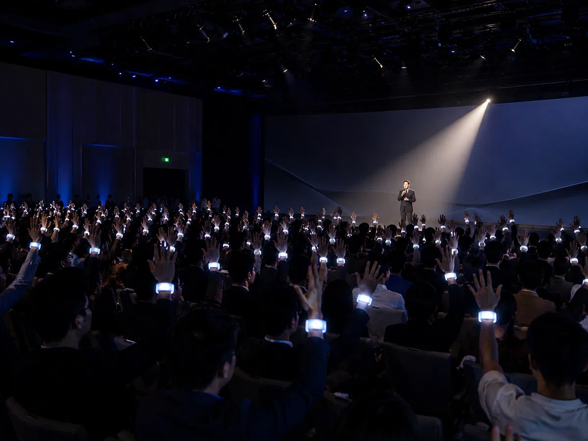 Corporate product launch audience wearing synchronized LED wristbands